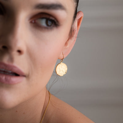 A pair of Gold Vermeil 3 Pence Coin Earrings made from real casting of Pre-Decimal Irish coin collection. The coins have been plated with 18ct gold over sterling silver, providing a durable and lustrous finish that catches the light beautifully. These stunning and unique earrings are versatile and can be worn for everyday wear or to complement a formal outfit. They are an excellent conversation starter and a must-have accessory.