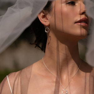 Close-up of a woman wearing wedding veil and Irish bridal jewellery by Loinnir Jewellery the Sterling Silver Twig earrings