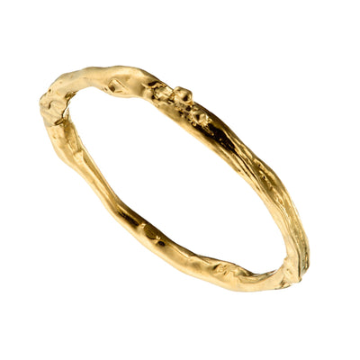 solid gold wedding ring with a twig design on a white background